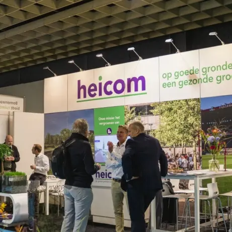 Bezoekers bij de verlichte beurswand van Heicom met plantenbakken