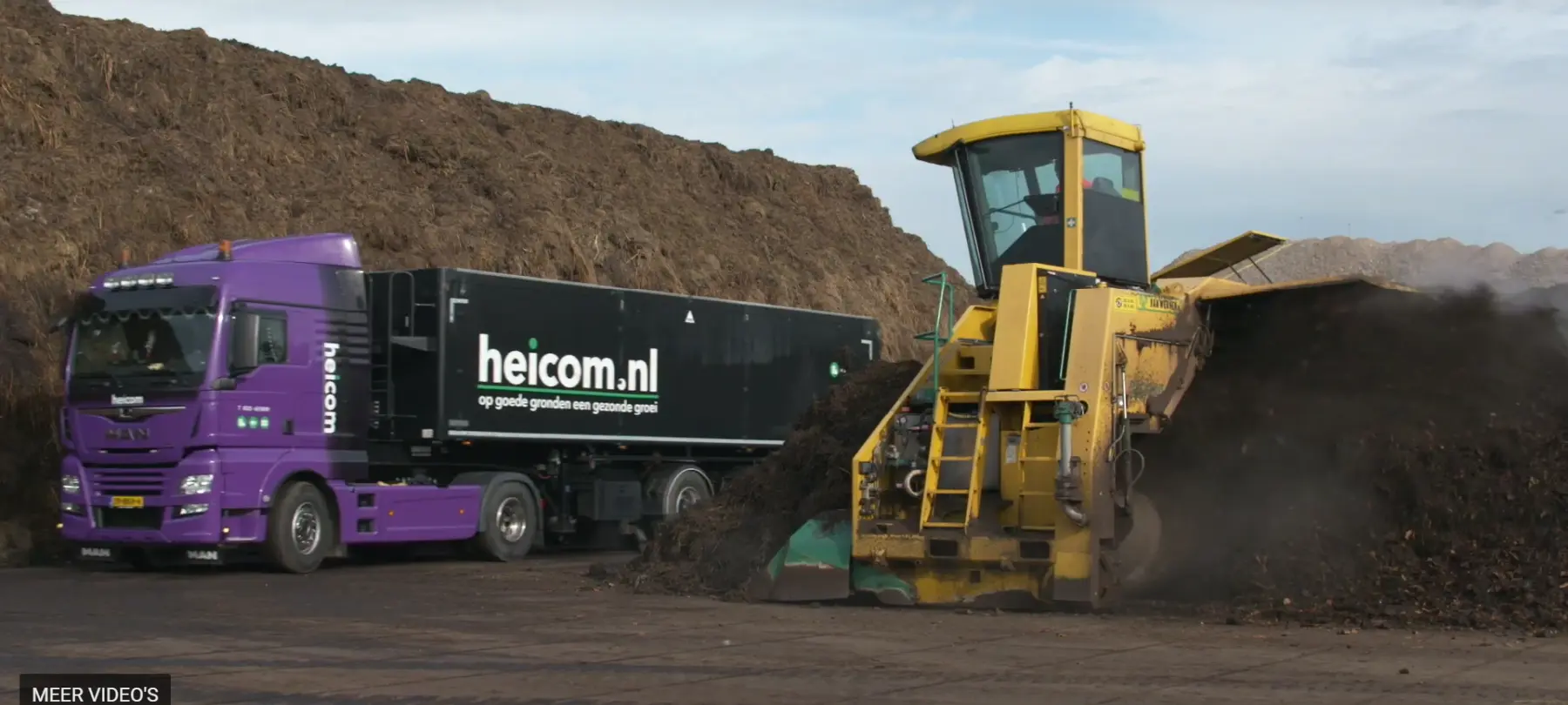 Compostkeerder bewerkt een composthoop naast een paarse Heicom-vrachtwagen