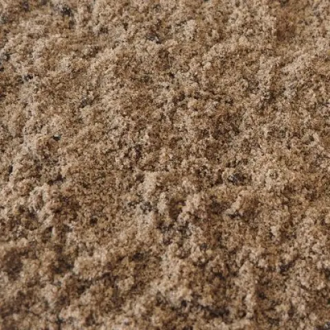 Lichtbruin zand vermengd met zwarte compostdeeltjes